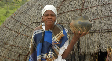Botswana Kalahari desert medicinal plants expert from the Tsetseng community in front of a traditional hut